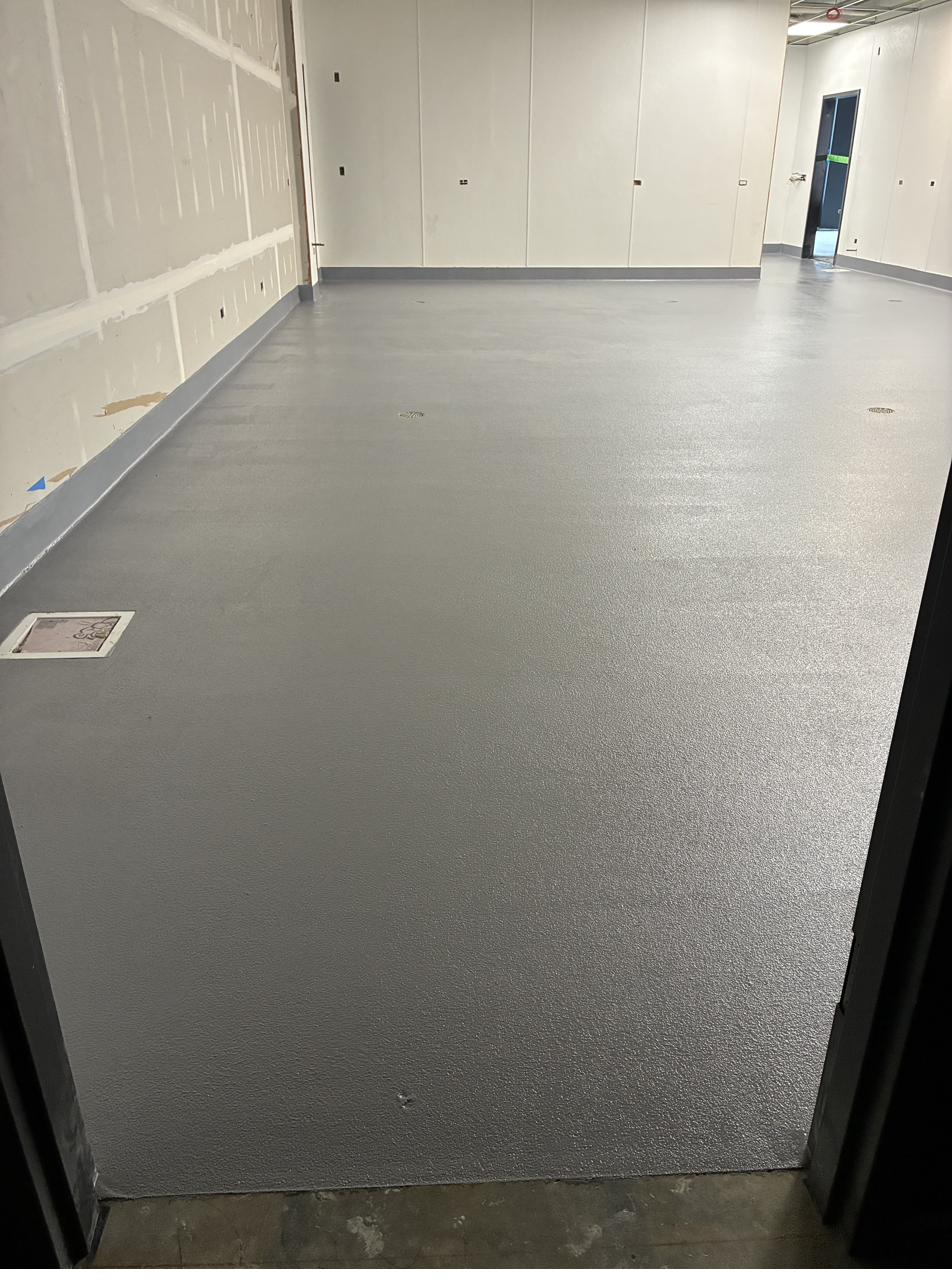 Grey textured epoxy corridor floor, new commercial construction in Wisconsin